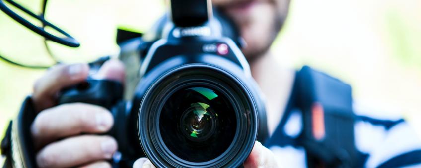 Image of person pointing a camera lens towards the screen